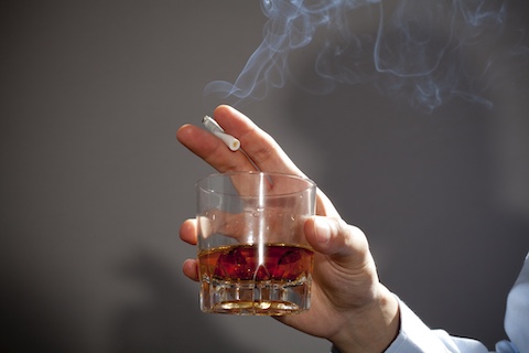 タバコとお酒を持っている手先