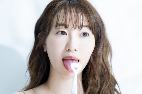 舌磨き専用クリーナーでケアしている女性