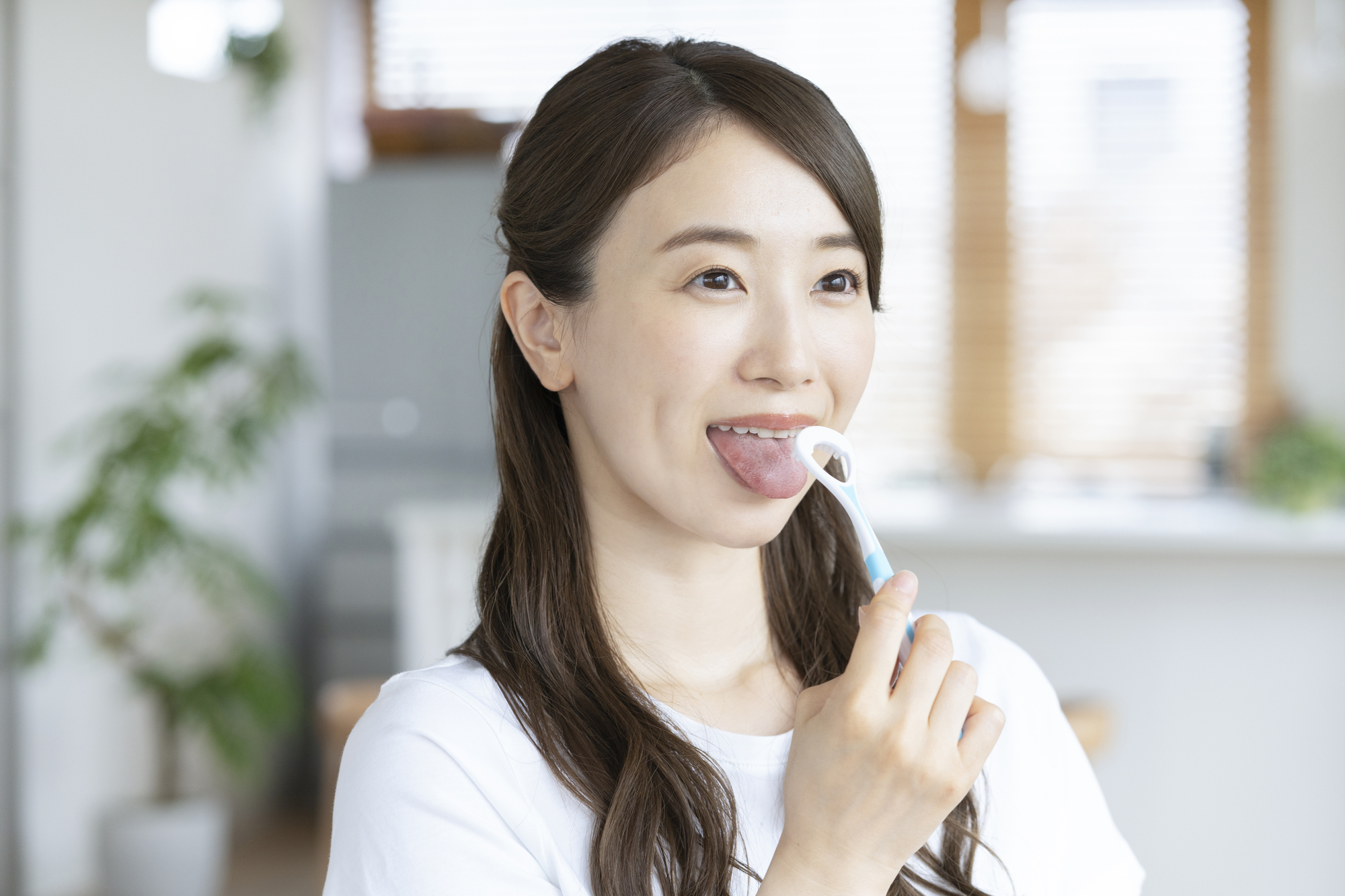 舌のクリーニングをする女性
