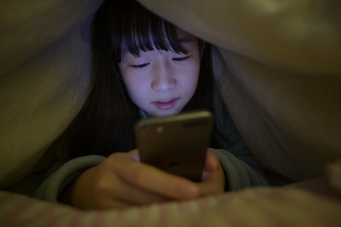 スマホを使用する子供