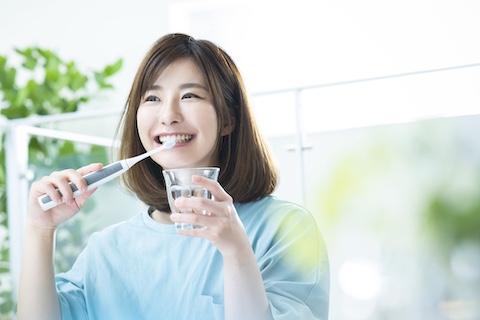 笑顔で歯を磨く女性