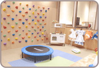 ボルダリングとトランポリンがあるキッズスペースの写真