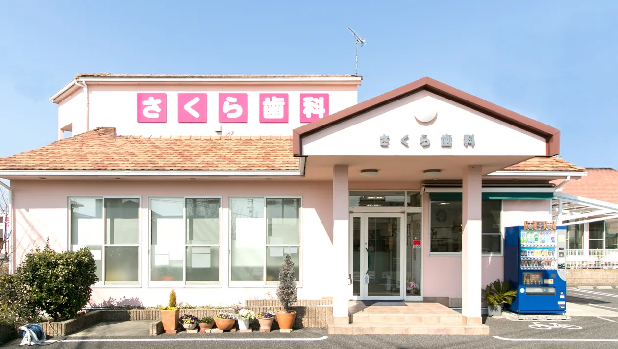 春日井市篠木町のさくら歯科 外観 - ピンク色の建物が目印